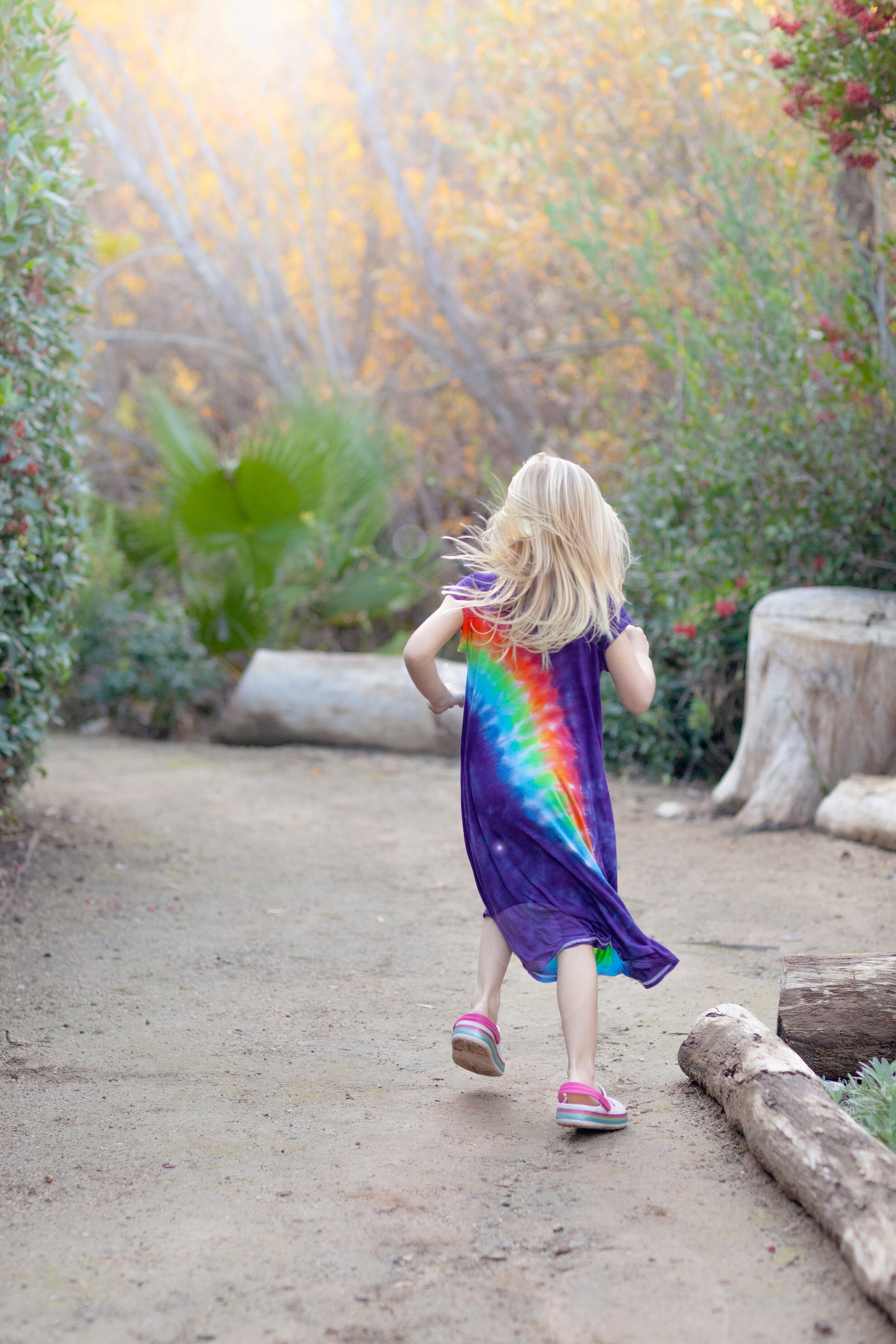 girl running away in rainbow sensory dress